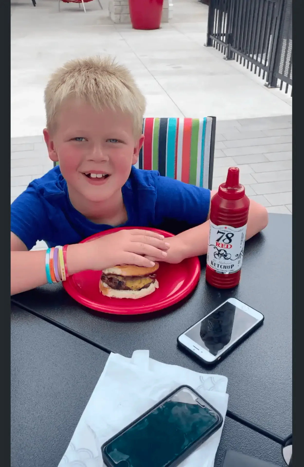 Kid biting into a burger with 78 Ketchup
